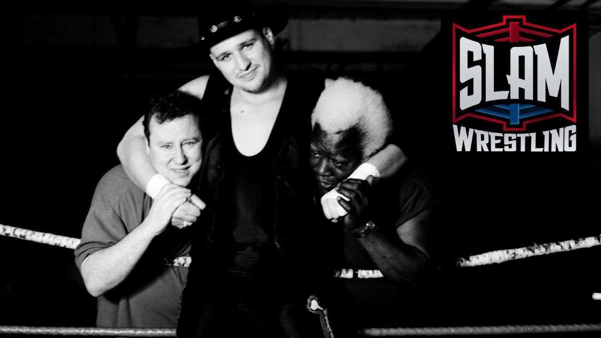 Trainers Ron Hutchison and Sweet Daddy Siki are headlocked by student 