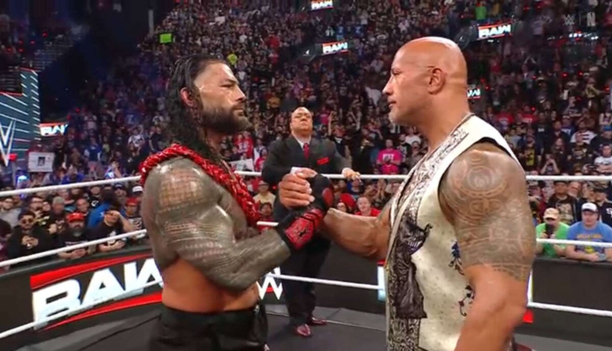 Rock shakes hands with Roman shortly before hugging him and kissing his forehead